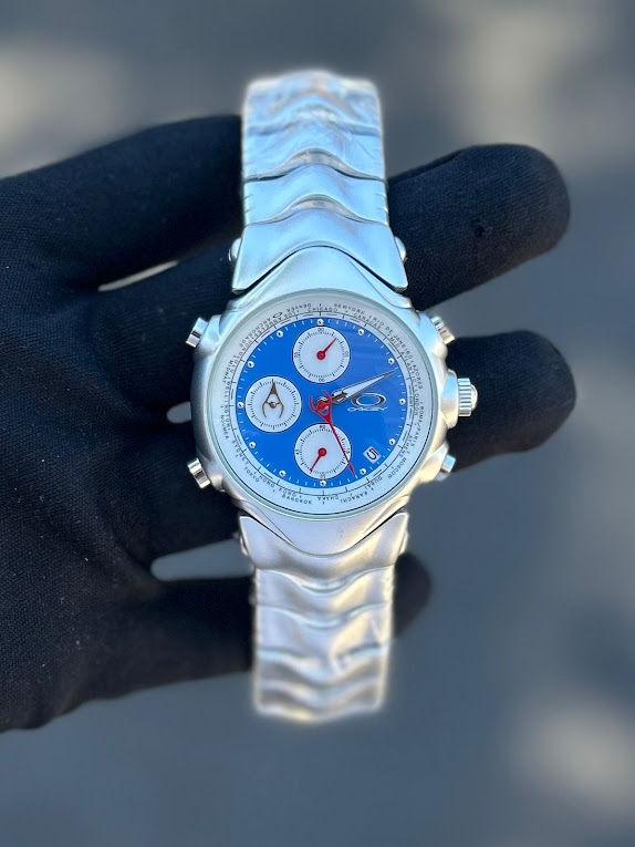 Relógio Oakley GMT Prata Com Azul no Atacado - Pulseira de Aço | Relógios Para Revender Relógio Oakley GMT Prata Com Azul no Atacado